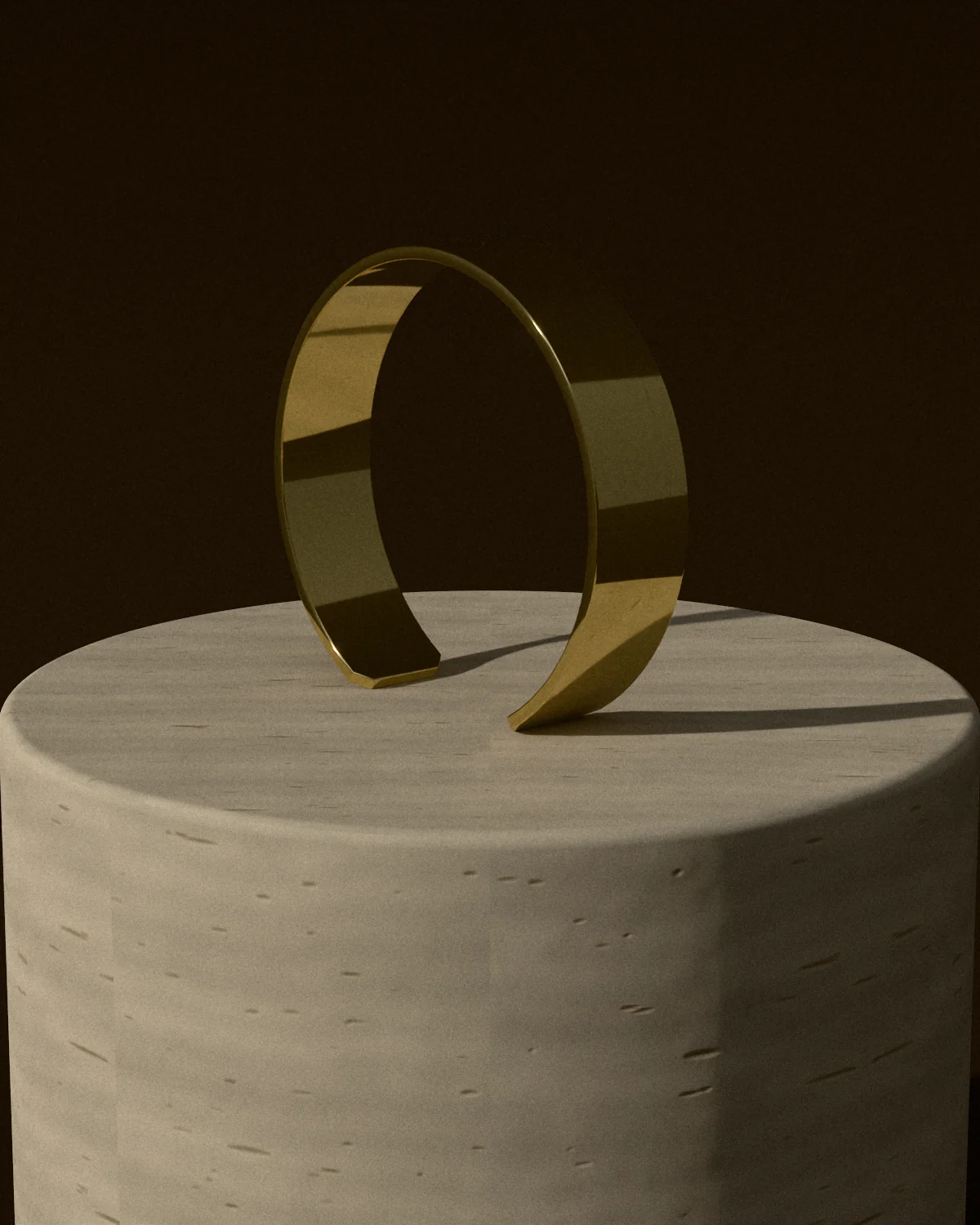 A polished brass cuff standing on a travertine plinth in low sun