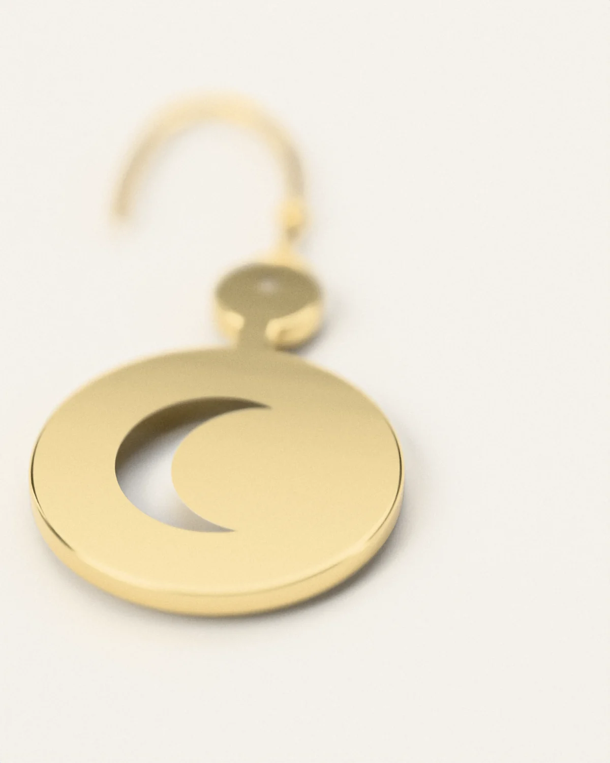 The cut edge of a brass crescent earring, close
